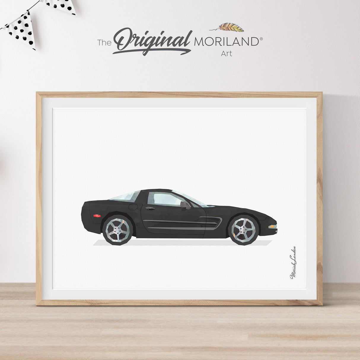 Modern heritage watercolor style illustration of a black C5 Corvette classic sports car side profile, displayed in a light wood frame for a car themed nursery or boy's room wall decor by MORILAND.