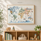 Watercolor world map for kids in a slim natural wood frame above a light wood nursery shelf with books, plants, and a sailboat.