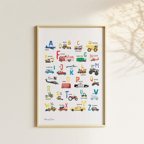 Watercolor vehicle alphabet poster displayed with matching transportation prints in a neutral children’s bedroom.
