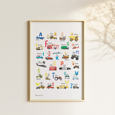 Watercolor vehicle alphabet poster displayed with matching transportation prints in a neutral children’s bedroom.
