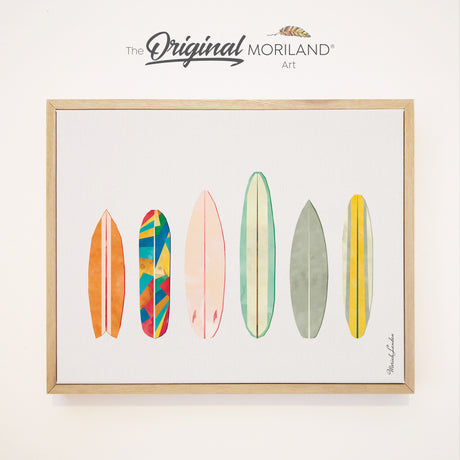 A horizontal lineup illustration of six retro surfboards with watercolor textures and colorful geometric patterns, displayed on a framed canvas print with a light wood frame.