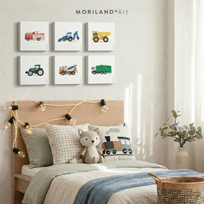 A gallery wall of six square, 1.5-inch thick canvas prints featuring colorful digital illustrations of transportation and construction vehicles, hung in a modern kids' room above a light wood bed.
